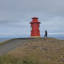 小島の頂上部に朱塗り灯台が設置されています