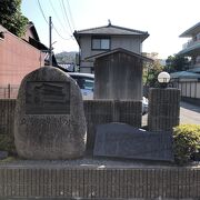 住宅街の駐車場前に駒札が建っています