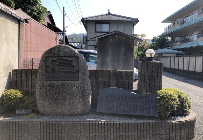 住宅街の駐車場前に駒札が建っています