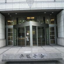 大岡越前忠相の屋敷跡の標識が置かれている弁護士会館の建物です