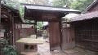 雑木林に古民家が建っています