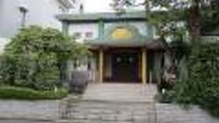 本堂が緑色の柱に白い壁です