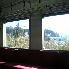 長椅子の席に座ってのんびり農村風景を眺める電車旅でした