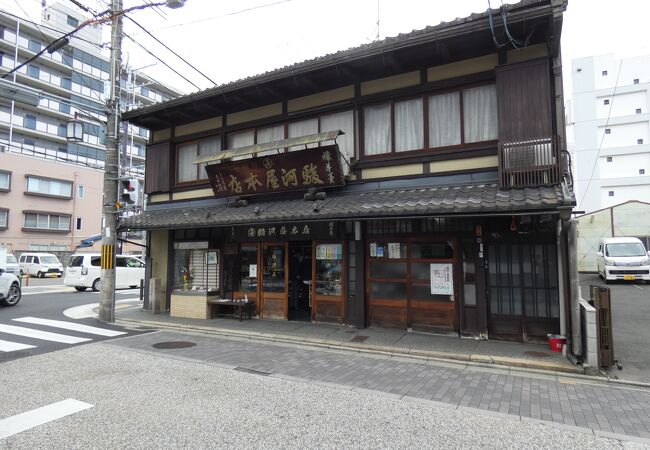 店の前に電気鉄道事業発祥地碑が建つ