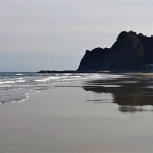 薄磯海岸から見た塩屋岬と、その上に立つ塩屋埼灯台のシルエット