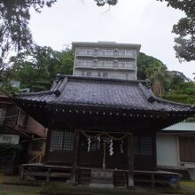 背後に被さるようにマンションが。