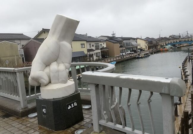 指のオブジェのある橋