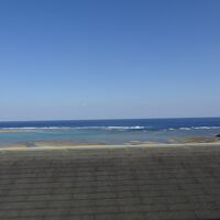 前の建物の屋根の奥に海が見えます。