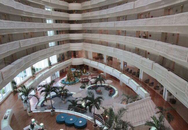 リゾート感溢れるガーデンプールを眺められる、吹き抜けの開放的なホテルのラウンジ