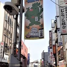 緑のマスコットキャラクター「ニッキー」が通りの旗に