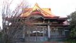 本堂の屋根が夕陽に映えて赤色とオレンジ色に