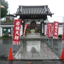 岩槻大師の山門と参道です。赤色の幟の文字が鮮やかです。