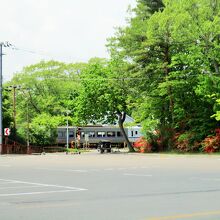 沼の家隣接した駐車場から大沼公園駅に向かって走る電車を撮影