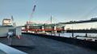 水門、モダンなデザインの橋、背後に広がる東京の活気ある街並