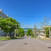 「常盤坂」同様、坂の上からまっすぐ先に海が見えますが、海の手前に建物があります。　