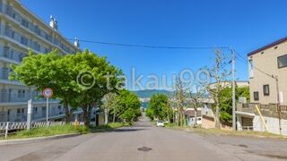 「常盤坂」同様、坂の上からまっすぐ先に海が見えますが、海の手前に建物があります。　