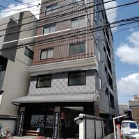 細長い建物。周囲には溶け込んでいる色合い。狭い路地に位置。