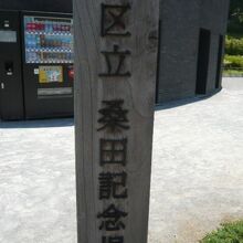 児童遊園の標識柱の背景に、トイレが見えます。立派なトイレです