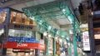 薄い青緑色の鉄骨が映えるアーケード