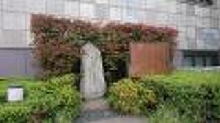 神田錦町の学士会館南側の植え込みにあります