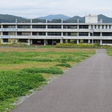 旧陸前高田市立気仙中学校の正面外観。駐車場やトイレのほか…、