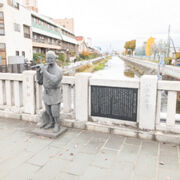 橋の上に笛吹権三郎さんの銅像があります