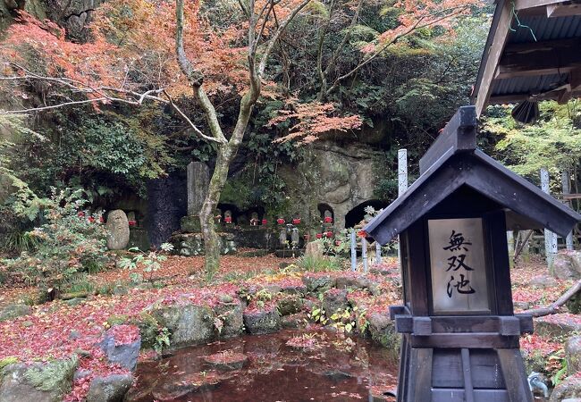 穴を掘り納められた石仏群と紅葉