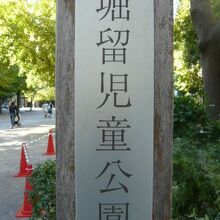 堀留児童公園の標識です。背景にも緑濃き公園内が映っています。