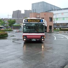 白い車体に赤いしましまのバスです