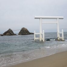 波打ち際から真っ白な鳥居と夫婦岩を見ました。