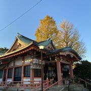 朱色の建物と緑の屋根に黄色い銀杏が映える