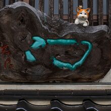 看板裏から瑞泉寺を見つめる木彫猫