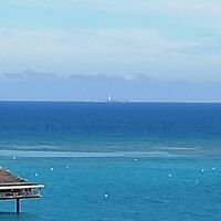 ベランダから水平線上に見えるアメデ島灯台