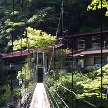 吊り橋の向こう岸に、煙突から煙を出す桃の木山の家