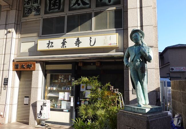 お寿司屋さんの前に小さなブロンズ像があります