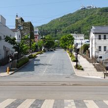 緩やかな坂を登る。後方は新緑の函館山。