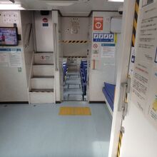 ２デッキ。ロングシートと車いす用スペース、トイレがある