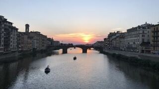 ヴェッキオ橋から眺めたアルノ川に沈む夕日。奥に見える橋はサンタ・トリニタ橋。