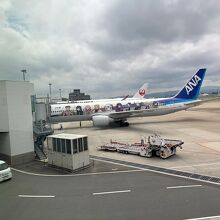 鬼滅の刃ラッピングのANA機がボーディングブリッジに駐機