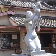 本堂前に子供を掲げる女性の像