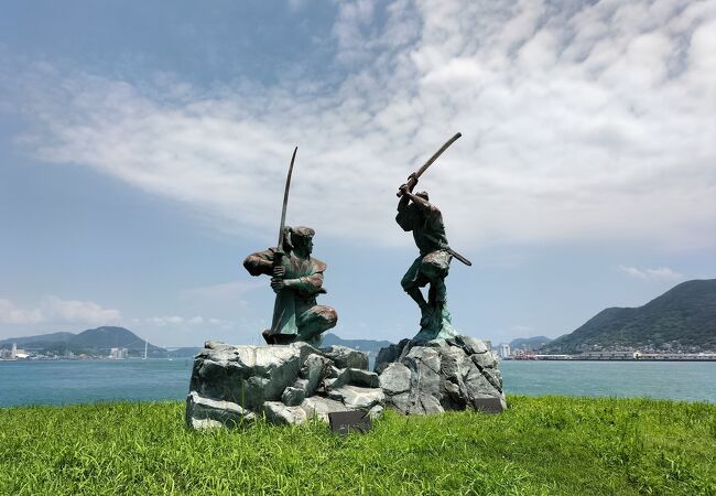 海上に2つの巌岩，男島、女島中央、左右，下部に流れる波