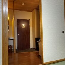 右側に冷蔵庫、左側に洗面台、その奥にバス付トイレがあります。