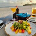 サンセットディナーがお勧め ビーチの砂浜に並ぶテーブル席でゆったりと食事を味わう