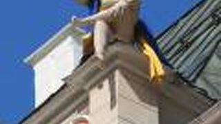 屋根の上に読書をしている男性の像が