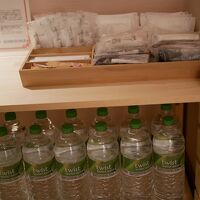 廊下に水のボトルと簡単なアメニティが並んでいます