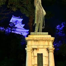 ブルーにライトアップされた高知城天守閣と銅像