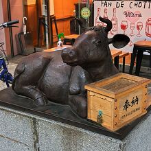 商店街の片隅に牛の銅像と賽銭箱がありました