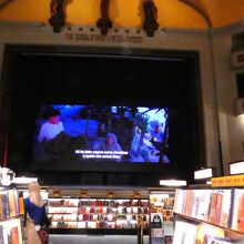 平土間には低めの本棚。スクリーンでは映画を上映中