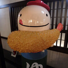 入口脇でエビフライを持った「なぞの旅人 フー」が迎えてくれた