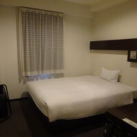 大きめで寝心地の良いベッド。カーテンはなぜかレースが内側に。